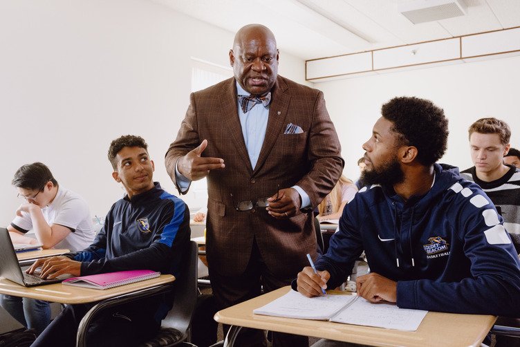 professor explaining to a classroom of students pursuing a degree in finance