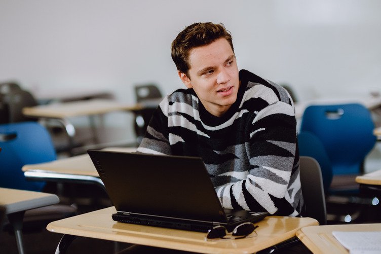 MBA in Business Analytics student on his laptop in aGBC classroom