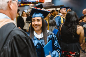 Graduating student shaking hands with a faculty member. 