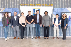Alumni standing in front of the Distinguished Alumni Gallery