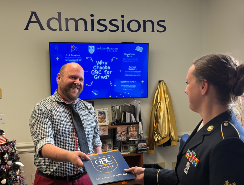 Soldier accepting a GBC folder from an admissions rep.