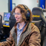 E-Sport player smiling because he is enjoying his time at practice in the G.B.C. E-Sports Room.