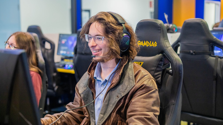 E-Sport player smiling because he is enjoying his time at practice in the G.B.C. E-Sports Room.