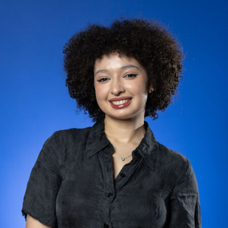 Jessica-Joy Kert, GBC student smiles in front of a blue background