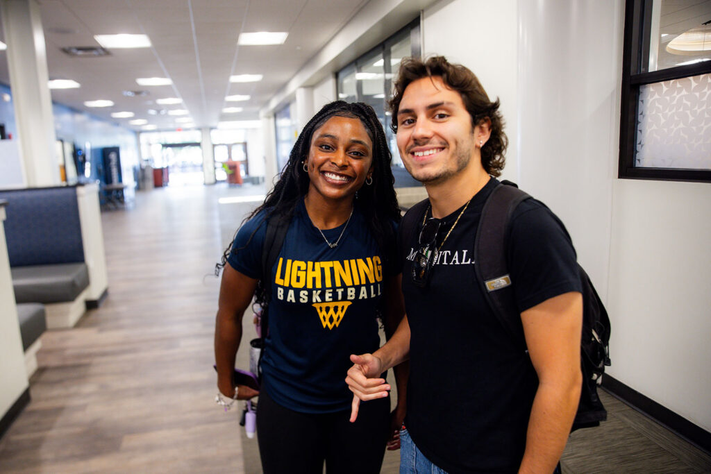 JJ Becerra and another Goldey-Beacom College student post for a photo in the Jones student lounge