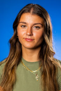 GBC student, Macy Hendin-Walker, posing in front of a blue background