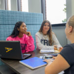 GBC student work together in the campus library with laptops and notebooks