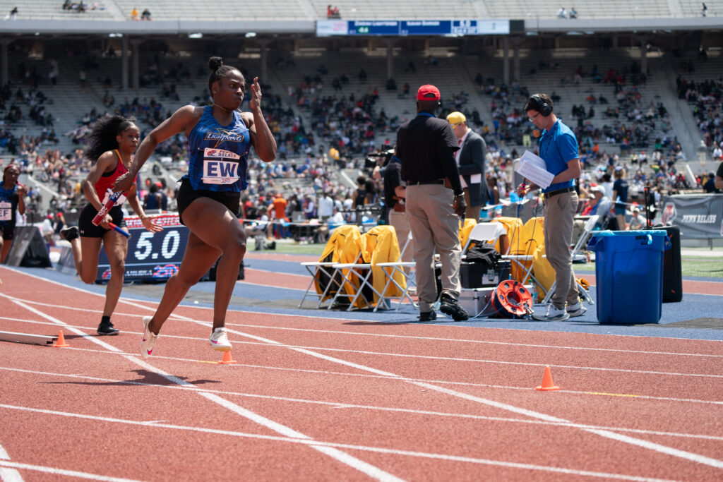 GBC track runner on the woman's team running in a competition.